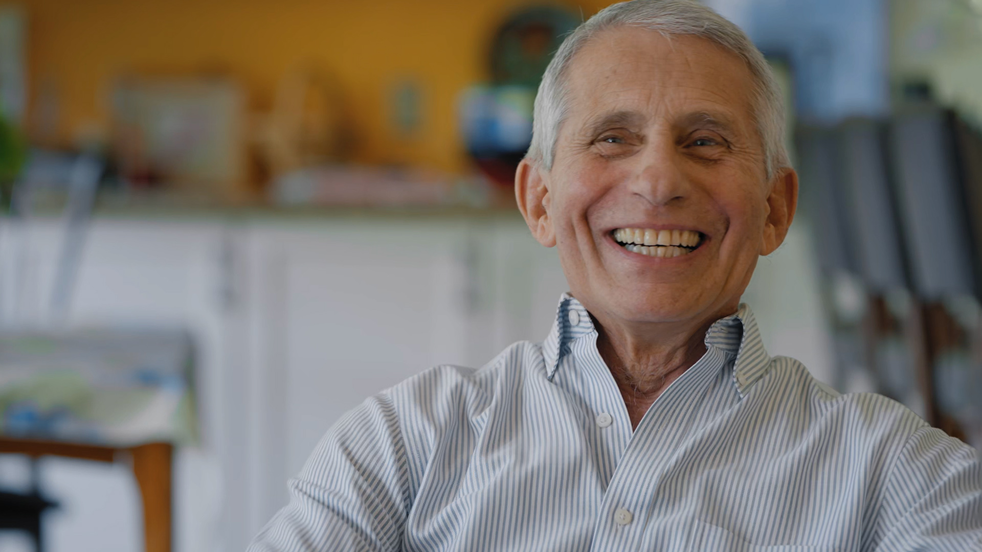 Dr. Anthony Fauci laughs while being interviewed in his home.