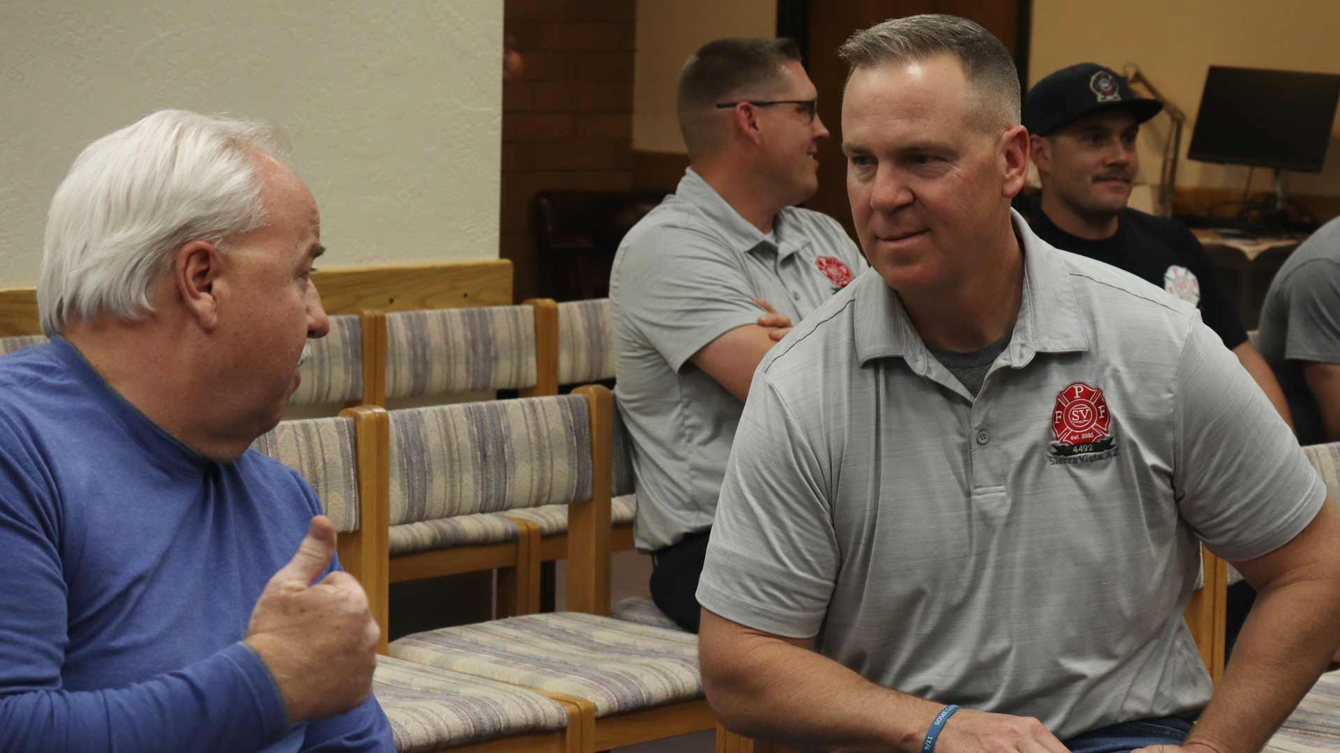 President of the Professional Firefighters of Sierra Vista Chris Klasen (right) talks with a member of the public during Thursday’s city council meeting.
