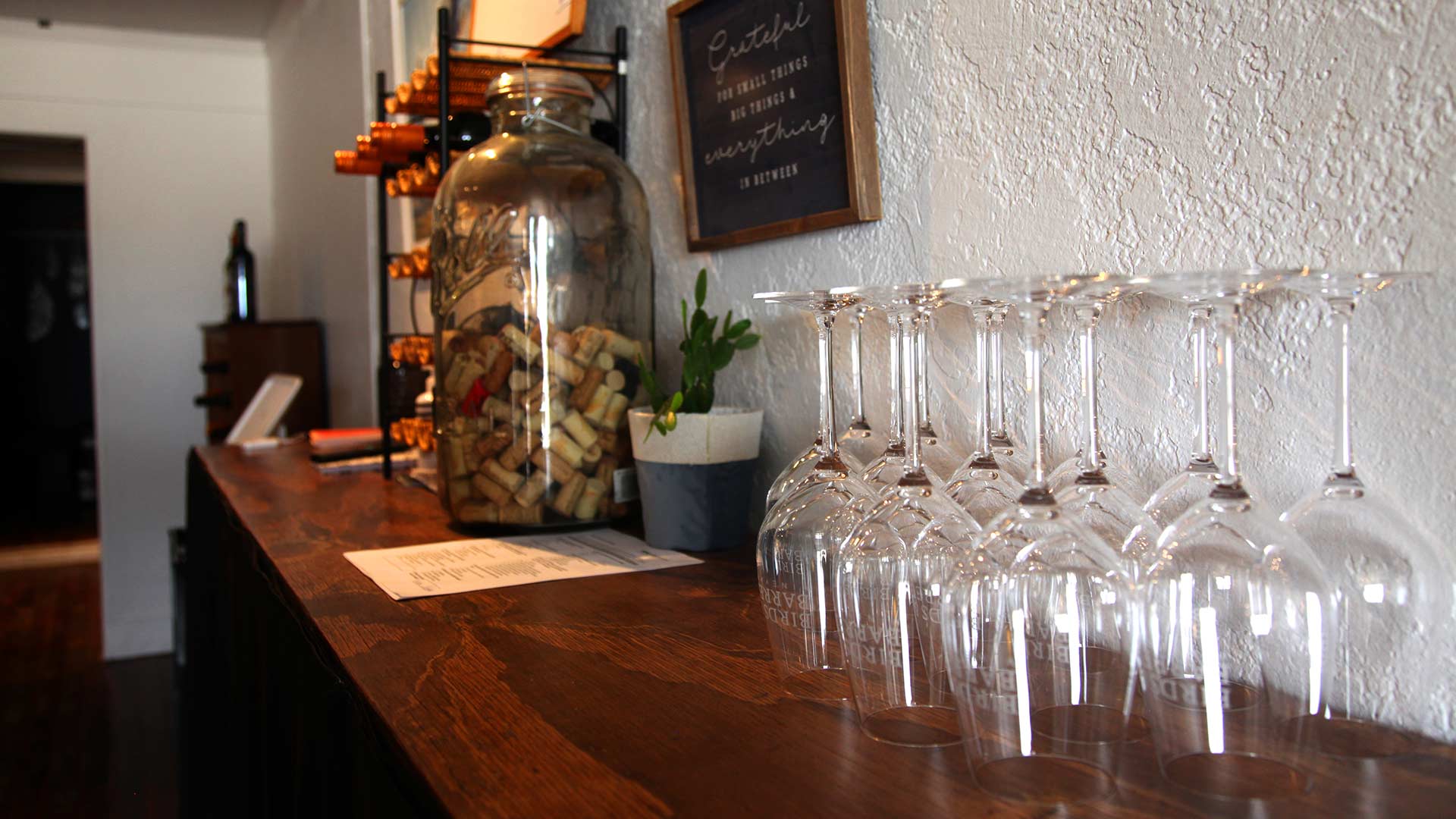 Wine glasses stand on a table in Birds and Barrels 