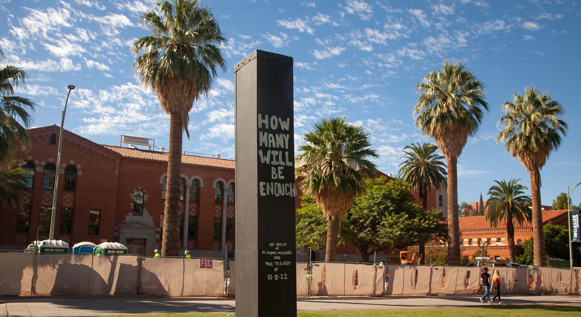A black pilar that says "How many will be enough" stands in the middle of the University of Arizona Mall one week after the killing of Professor Thomas Meixner on campus. A few days prior university officials held a candlelight vigil where the pilar stands. 