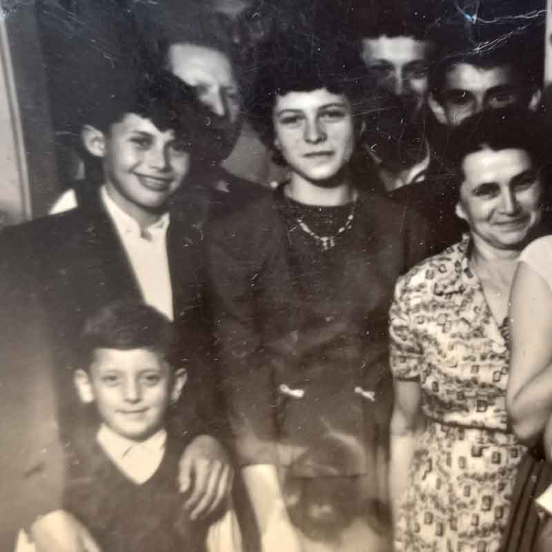 Simon Katz (second row, second from left) before the Holocaust. After the war, 15-year-old Simon returned to his hometown, Munkacs, and was reunited with his father (far right). Their family home and land had been taken over by Gentiles. His father opened a food business across the street and started over. He remarried a woman 22 years his junior who was also a survivor. Three years later, Simon married her younger sister, Helena.