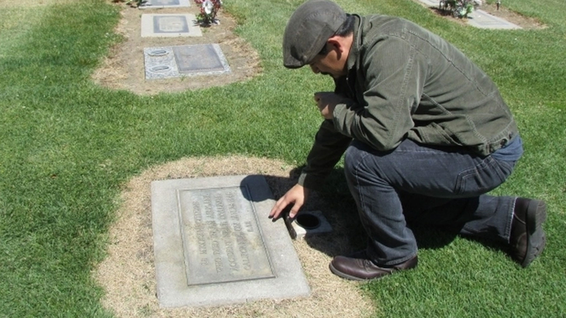 University associate professor and author, Tim Z. Hernandez, visits the headstone in Fresno where most of the 1948 airplane crash victims were buried. 