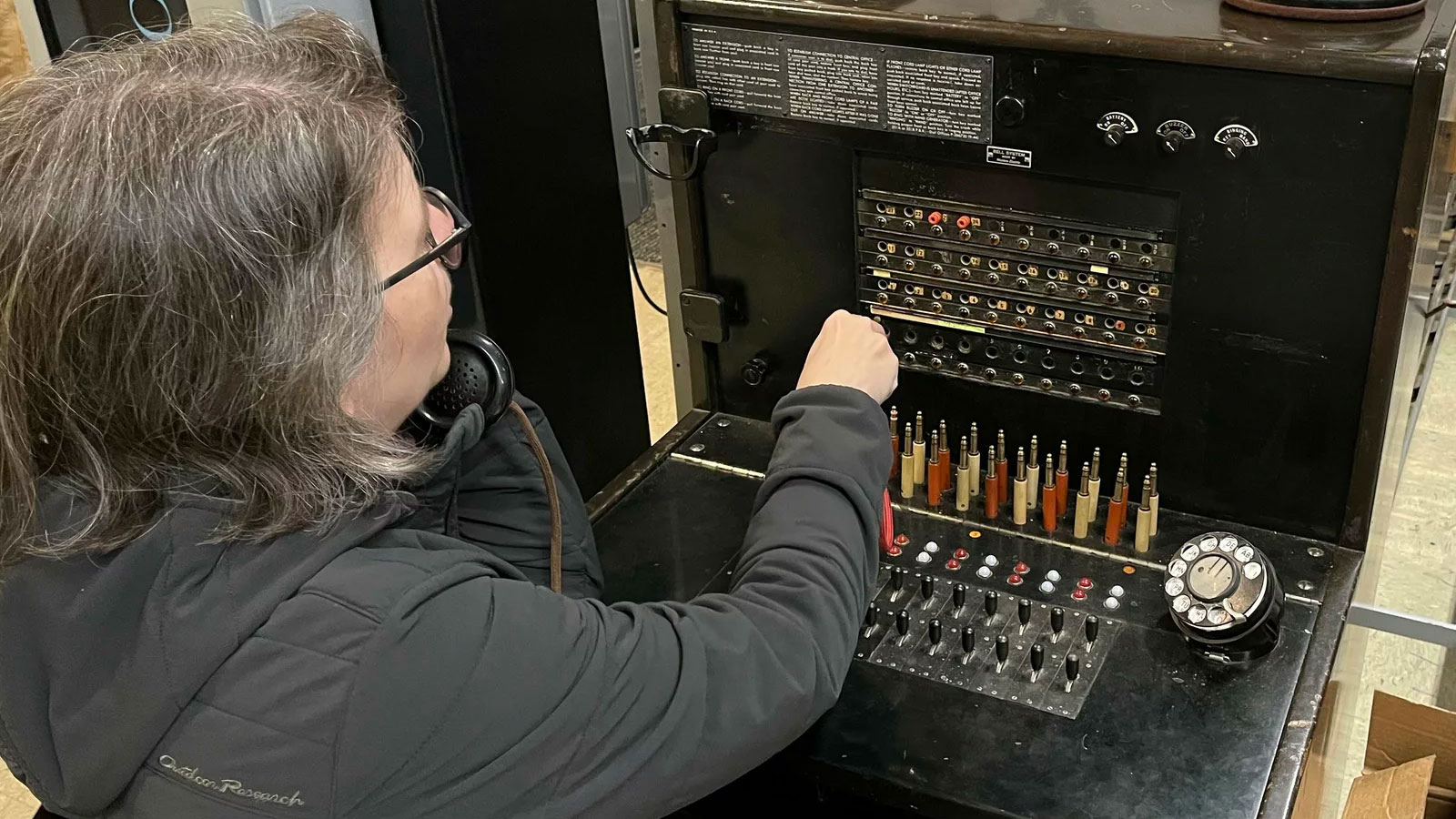 A visitor at the Connections Museum works the kind of switchboard system that first connected American phone users.
