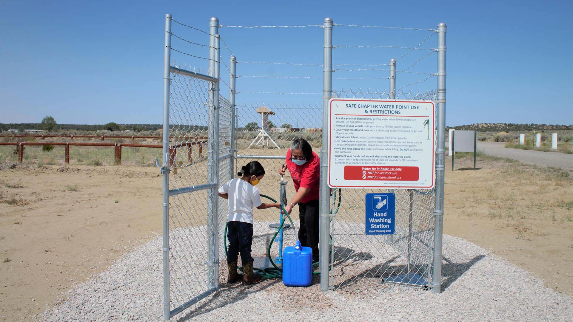 Navajo Nation family collecting water from local well.