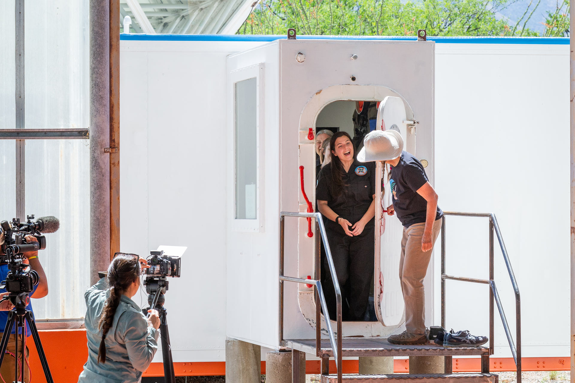 Cassandra Klos, mission commander, left, is greeted by Linda Leigh, right, one of the original eight Biospherians as the door is opened on the Space Analog for the Moon and Mars on Tuesday May 2, 2023 at Biosphere 2 in Tucson.