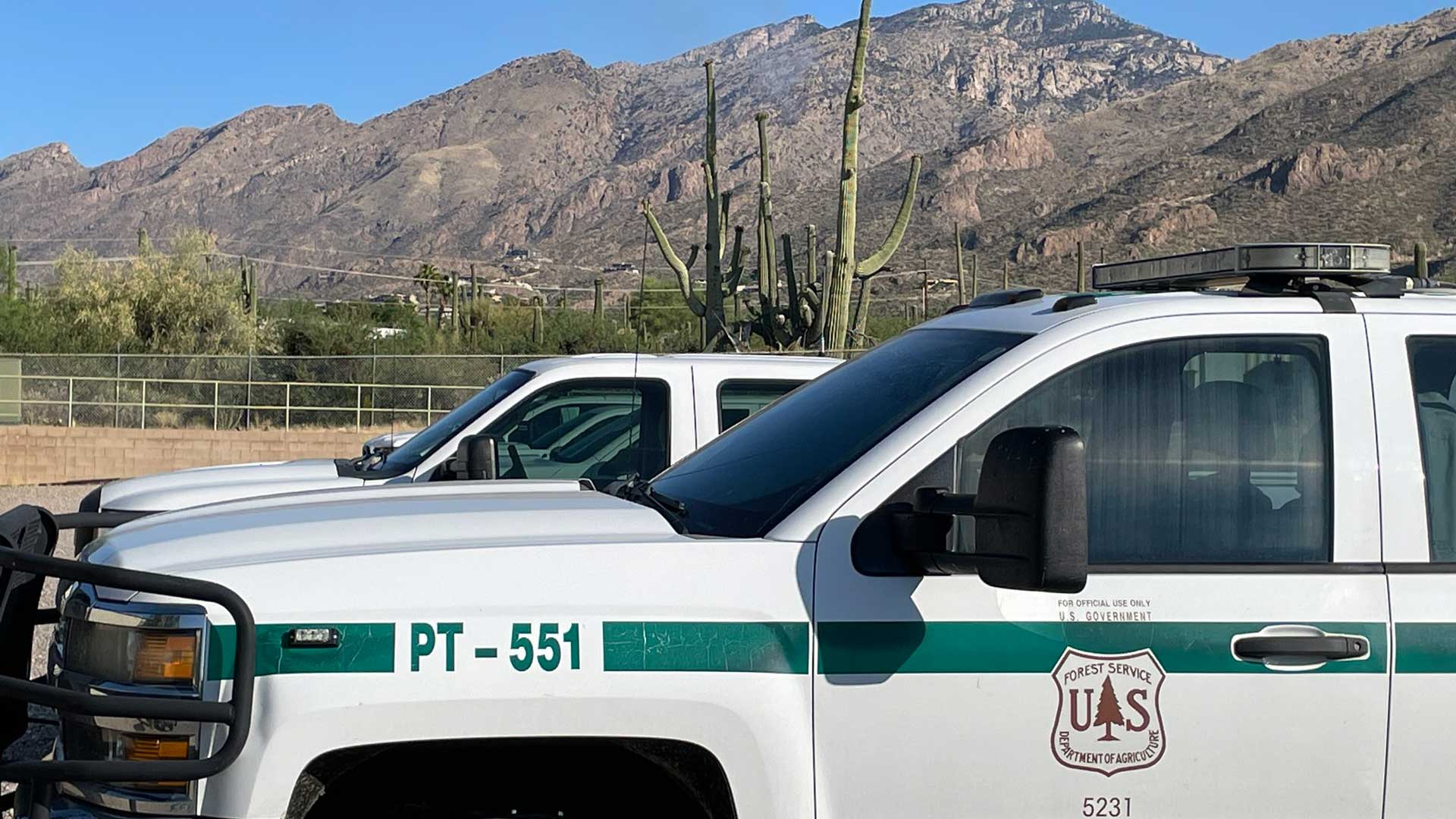 Forest Service vehicles in Tucson with smoke from the Ventana Fire in the background. June 20, 2023