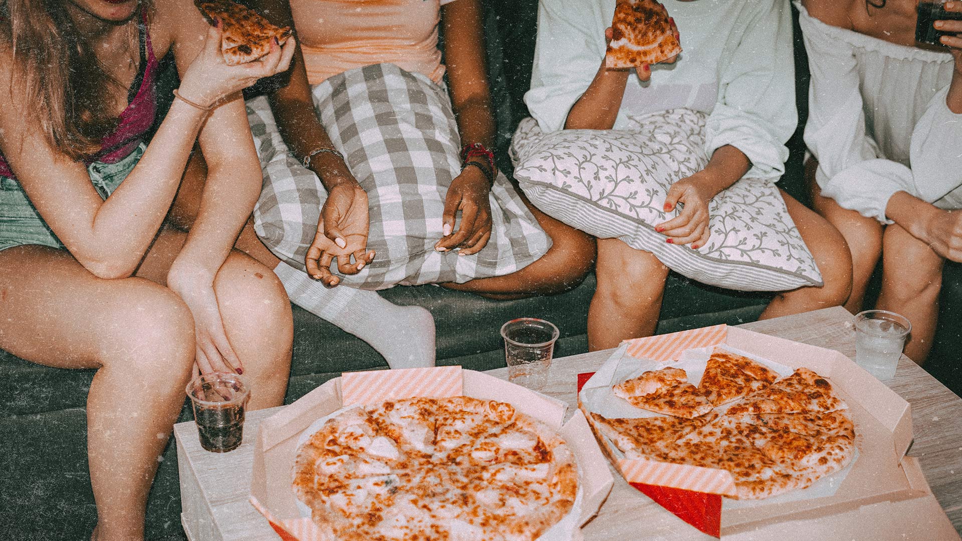 Girls enjoying pizza and soda at a sleepover party.