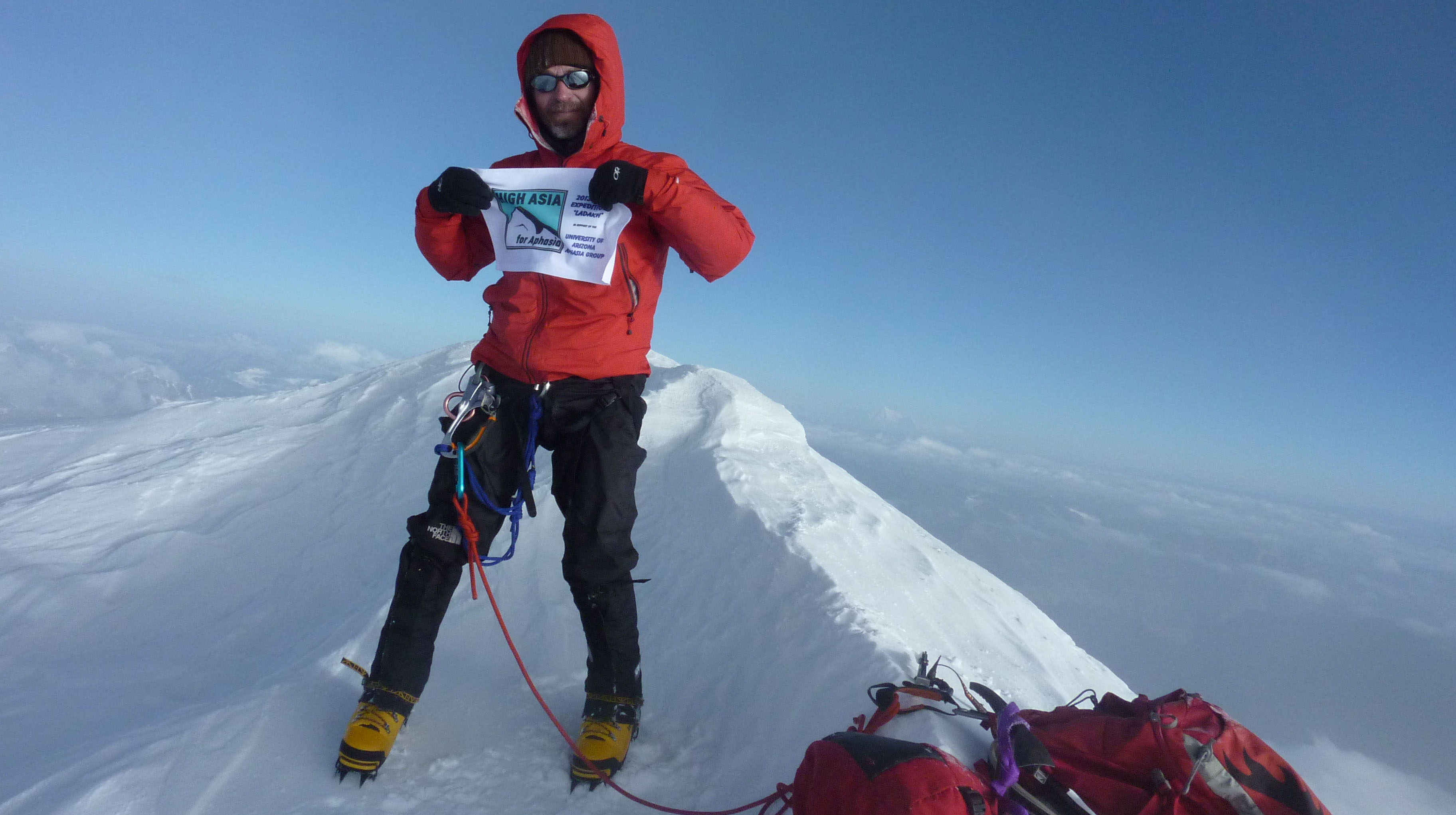 Greg Leonard plants the flag of the Friends of Aphasia on the summit of Mount Kun in the Indian Himalayas (23.218 ft.).