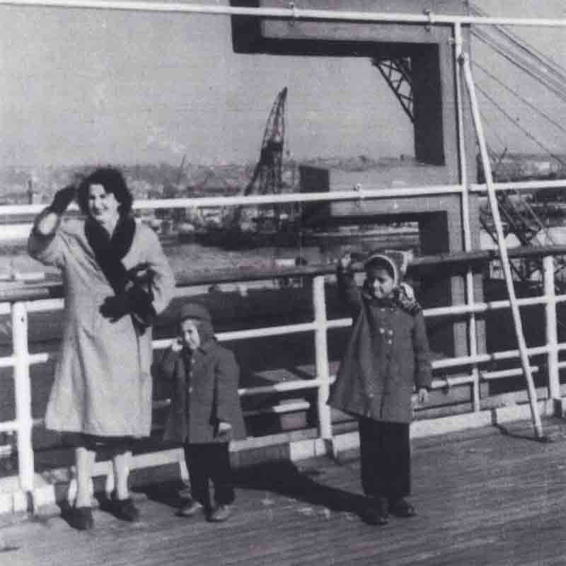 Chris (right) with her brother, Mark, and their mother aboard the ship that brought them to the United States.
