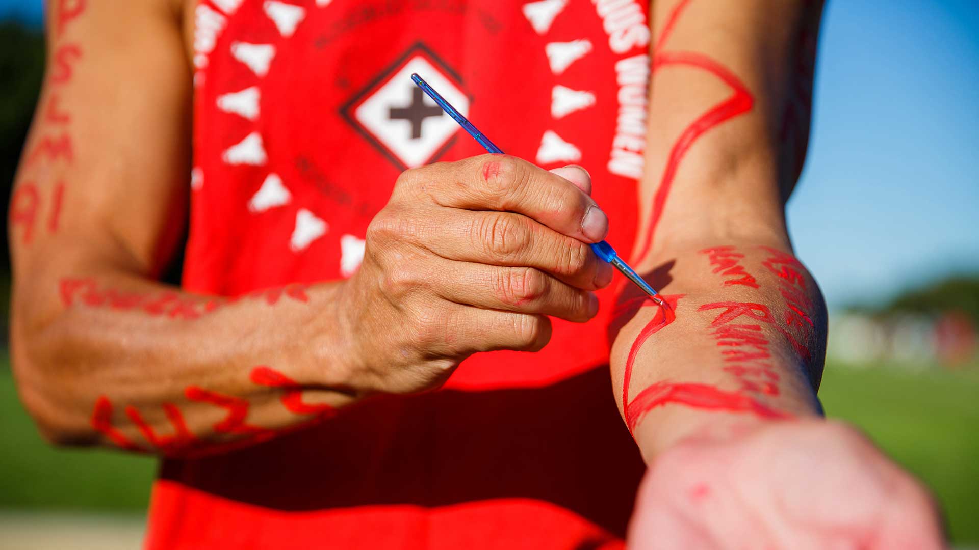 Duane Garvais-Lawrence paints the name of a missing Indigenous woman on his arm before starting a run around the National Mall in Washington, D.C., during the final stop in 2021 for the MMIW Bike Run USA to raise awareness of the issue of missing and murdered Indigenous women.
