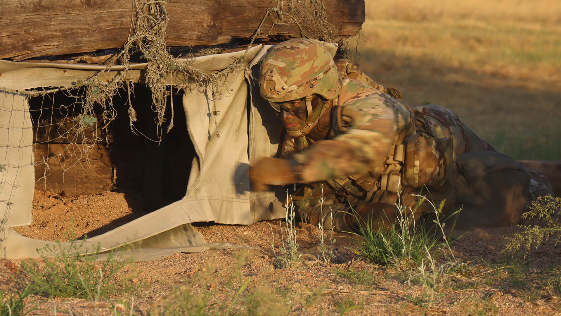 Staff Sergeant Gabriel Martinez throws an imitation grenade into a bunker as part of the U.S. Army Training and Doctrine Command Best Squad Competition's grenade assault course. August 28, 2023. 