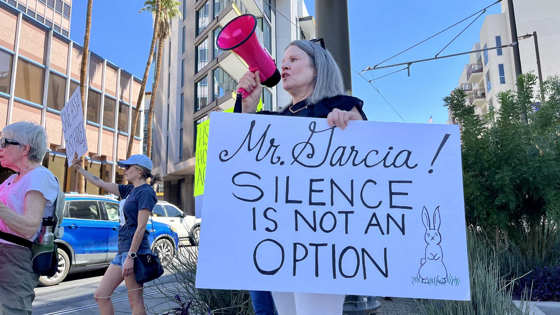 Animal advocate Kelly Galligan leads a chant as protestors call for answers on what happened to 250 small pets, on Sept. 27, 2023, outside the downtown Tucson law office of Robert Garcia, chairman of the Humane Society board.
