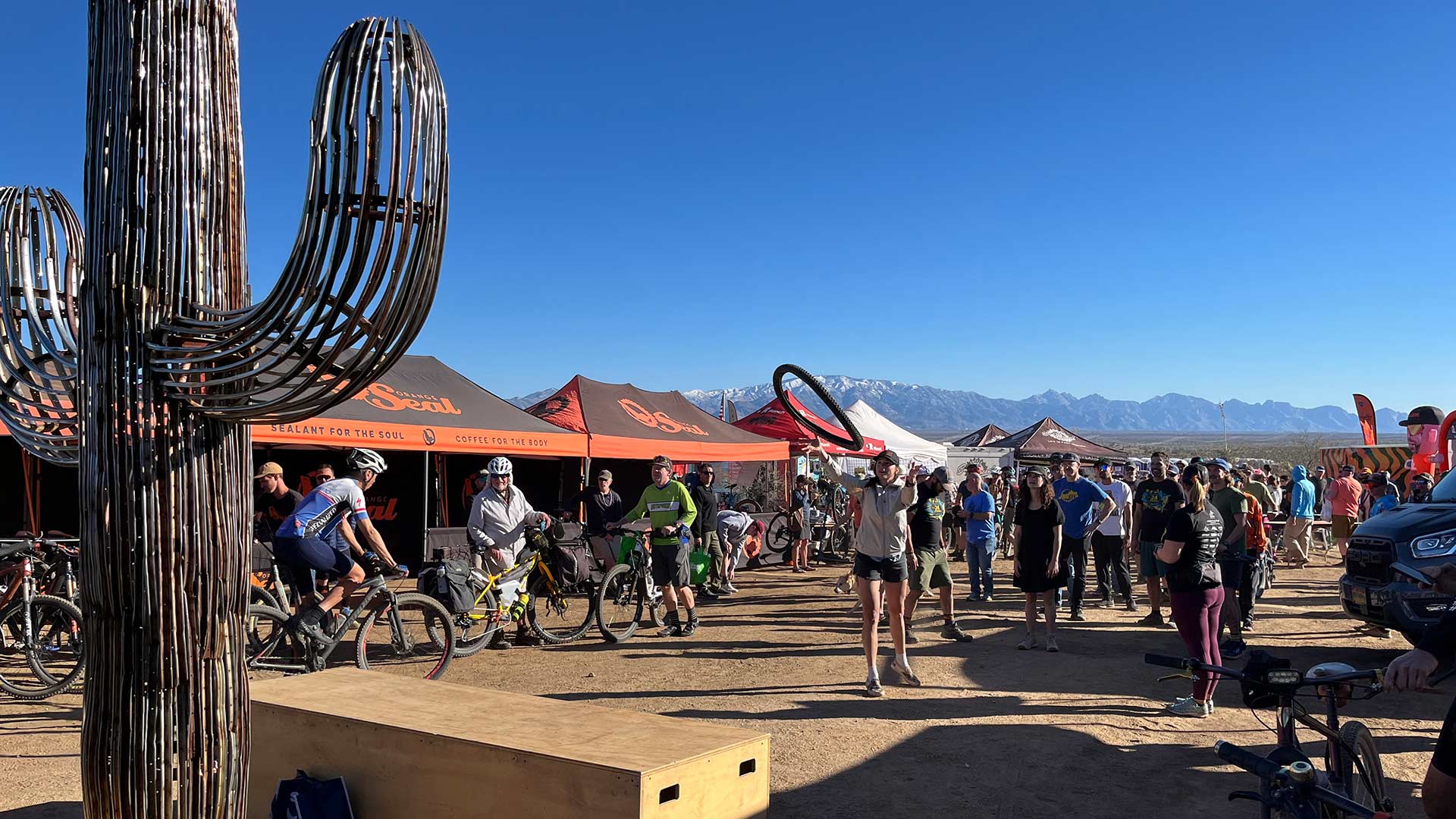 People line up to try and land an old tire on the BICAS cactus.