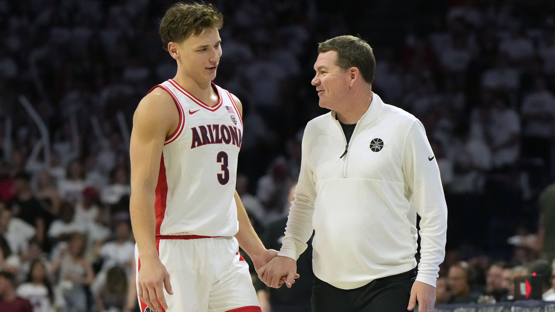 Arizona head coach Tommy Lloyd and guard Pelle Larsson (3) celebrate during the second half of an NCAA college basketball game against Washington, Saturday, Feb. 24, 2024, in Tucson, Ariz.