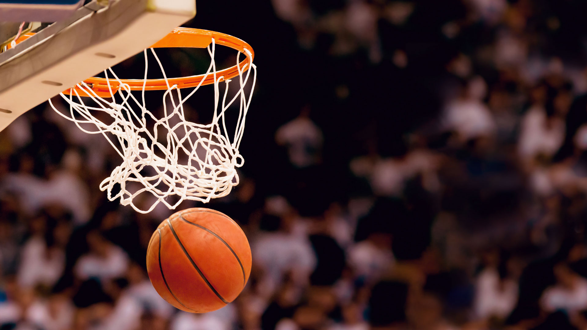 A basketball goes through a hoop.