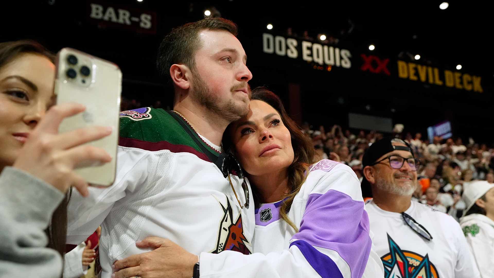 Arizona Coyotes season-ticket holders comfort one another as time expires in team's NHL hockey game against the Edmonton Oilers on Wednesday, April 17, 2024, in Tempe, Ariz. The Coyotes won 5-2. Coyotes owner Alex Meruelo agreed to sell the franchise's hockey operations to Utah Jazz owner Ryan Smith, who intends to move the team to Salt Lake City. 