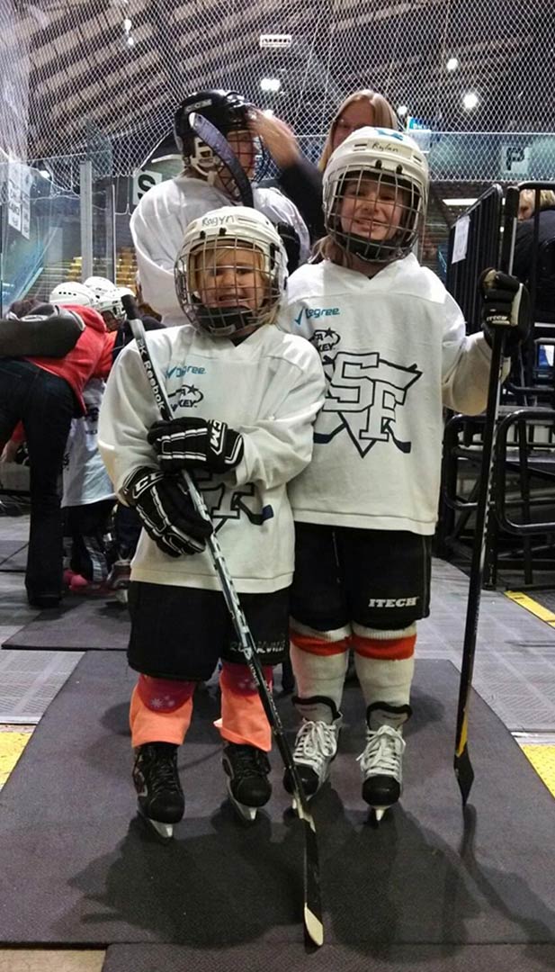 Rylan and Ragyn pose for a photo in hockey gear