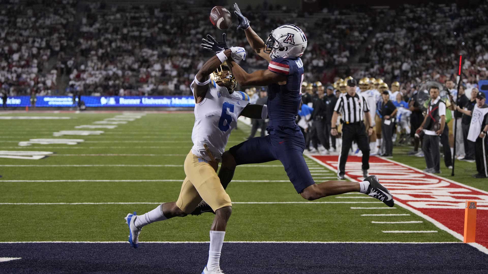 Arizona wide receiver Tetairoa McMillan (4), right, catches a touchdown pass in front of UCLA defensive back John Humphrey during the second half of an NCAA college football game Saturday, Nov. 4, 2023, in Tucson, Ariz. One of the highest-rated recruits in program history two years ago, McMillan has lived up to the hype.