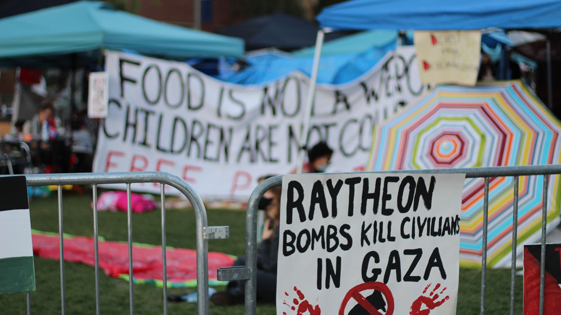 A sign calls for university divestment in Raytheon, a weapon's manufacturer in the University of Arizona's pro-Palestine encampment on Monday, April 29, 2024. 