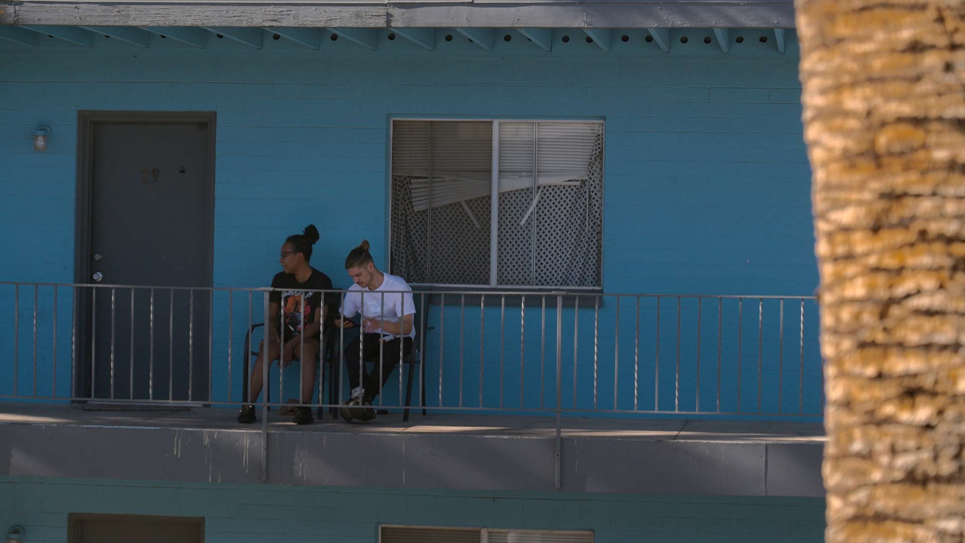 Residents of the Malibu Apartments complex sit outside their units.