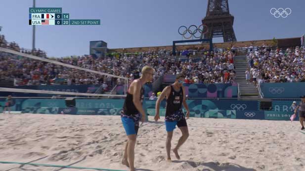 Chase Budinger and his partner, Miles Evans beneath the Eiffel Tower during Team USA's opening match of the Olympic beach volleyball tournament vs. France.