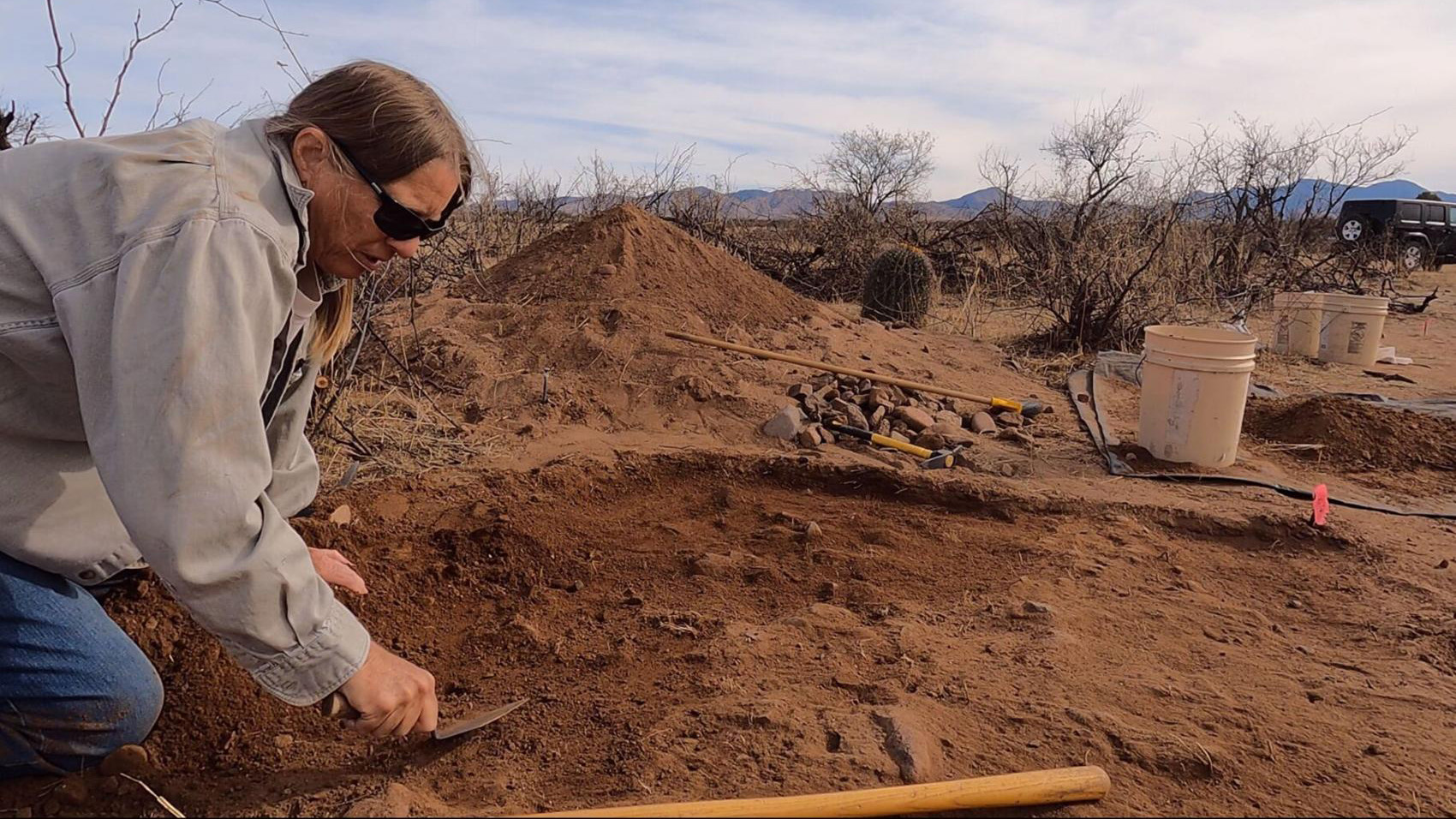 Archeologist Dr. Deni Seymour at work in the desert unearthing artifacts.