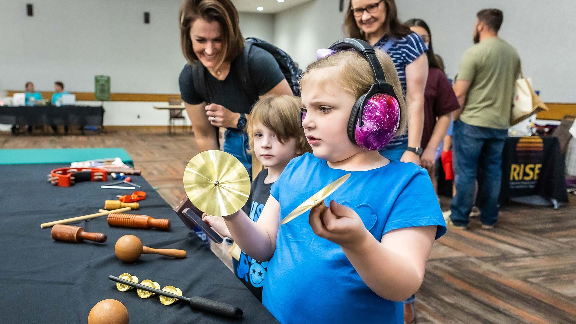 A girl explores the instrument petting zoo at the 2024 "All in for Autism Day."