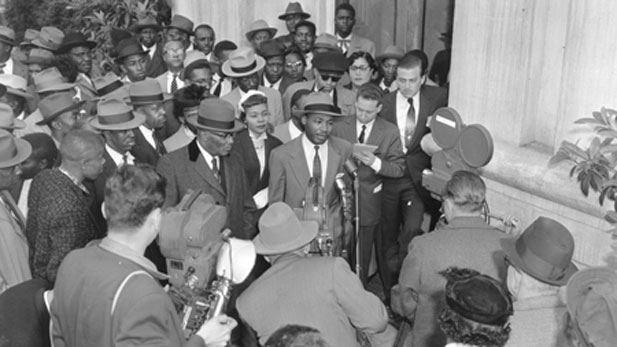 Following his arrest for leading the 1956 Montgomery bus boycott, the Rev. Martin Luther King, Jr., speaks to reporters. King -- 26 years old at the time -- and 92 others were charged with violation of Alabama's anti-boycott law. From AMERICAN EXPERIENCE: EYES ON THE PRIZE. (AP Photo/Gene Herrick)